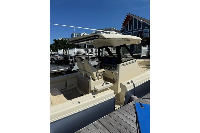 Slide: The Image of 2019 Chris-Craft Catalina 30 boat docked near waterfront homes under clear blue sky. - 5