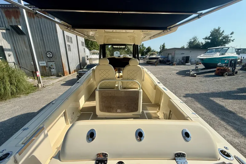 Slide: The Image of 2019 Chris-Craft Catalina 30 boat interior with seating and canopy in a marina setting. - 13