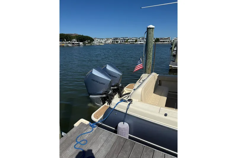 The Image of 2019 Chris-Craft Catalina 30 docked with dual Mercury engines, American flag displayed. - 0