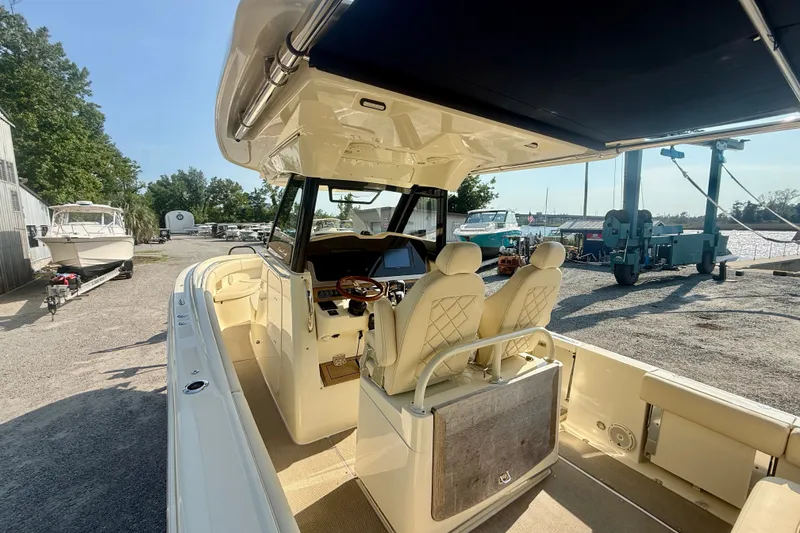 Slide: The Image of 2019 Chris-Craft Catalina 30 boat interior with helm and seating, docked outdoors. - 15