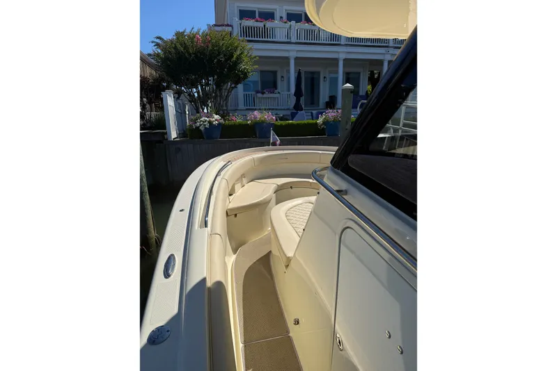 Slide: The Image of 2019 Chris-Craft Catalina 30 boat docked near a waterfront house. - 6
