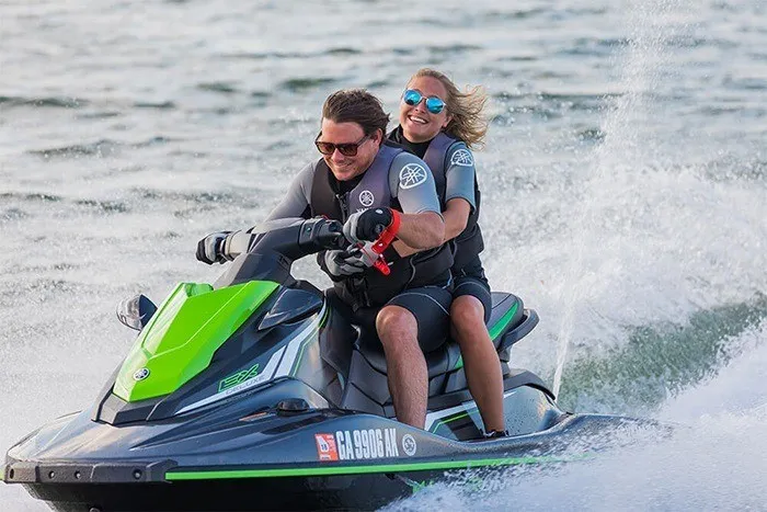 Slide: The Image of Two people ride a Yamaha EX Deluxe jet ski on the water, both wearing life jackets. - 8