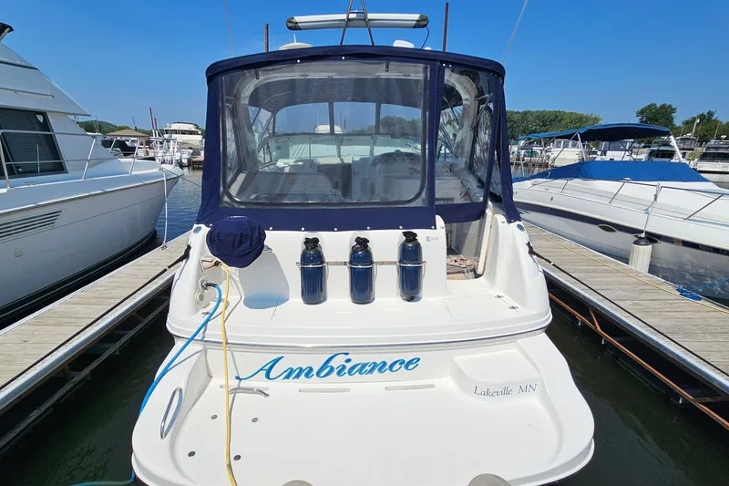 Slide: The Image of 2001 Mustang 3200 Sport Cruiser docked at marina, featuring "Ambiance" name on stern. - 5