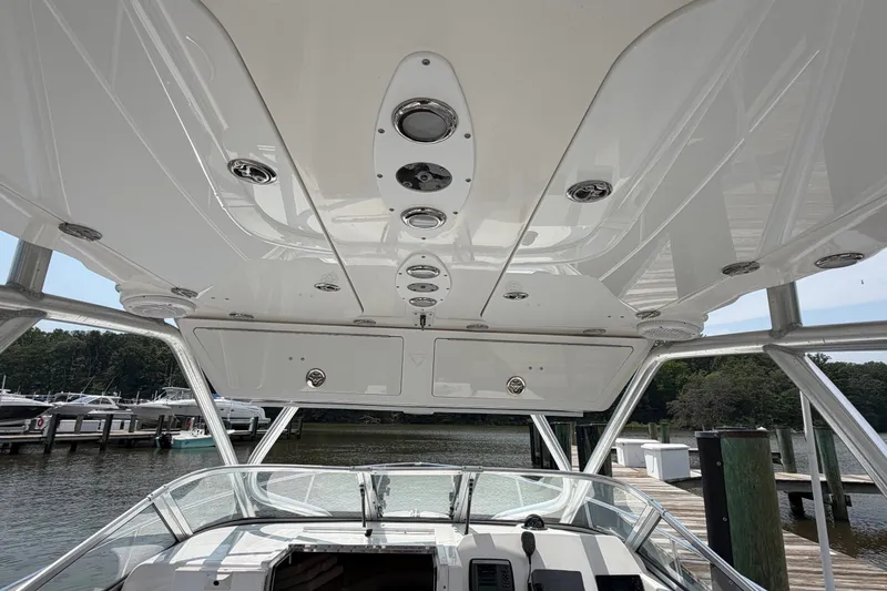 Slide: The Image of Interior view of 2013 Sea Fox 256 Voyager boat at dock, showcasing helm and overhead compartments. - 18