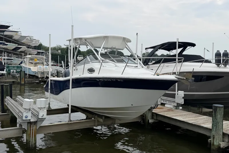 Slide: The Image of 2013 Sea Fox 256 Voyager boat docked at marina, featuring sleek design and white hull. - 2