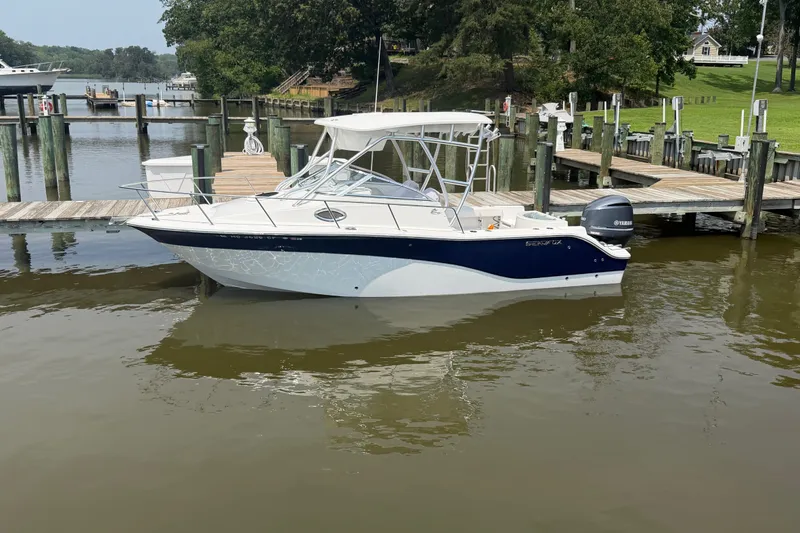 Slide: The Image of 2013 Sea Fox 256 Voyager boat docked at a marina with calm waters. - 6