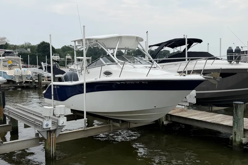 Slide: The Image of 2013 Sea Fox 256 Voyager boat docked at marina, side view. - 3