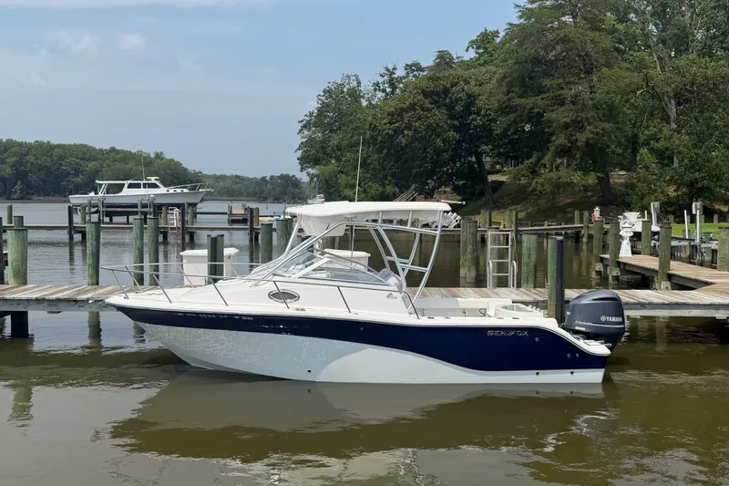 The Image of 2013 Sea Fox 256 Voyager boat docked at a serene marina. - 0