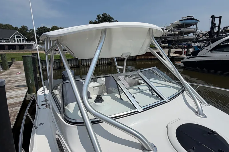 Slide: The Image of 2013 Sea Fox 256 Voyager boat docked, featuring sleek design and sturdy T-top. - 27