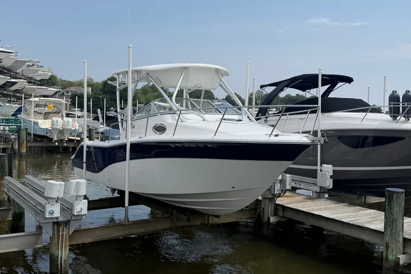 Slide: The Image of 2013 Sea Fox 256 Voyager boat docked at marina, surrounded by other vessels. - 8