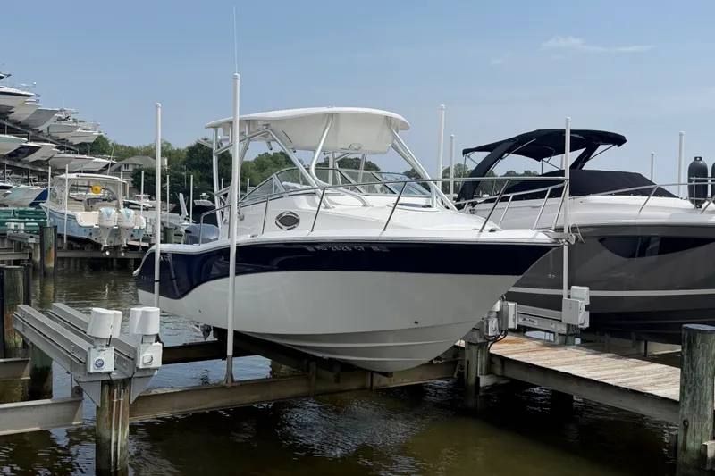 Slide: The Image of 2013 Sea Fox 256 Voyager boat docked at marina, side view. - 7