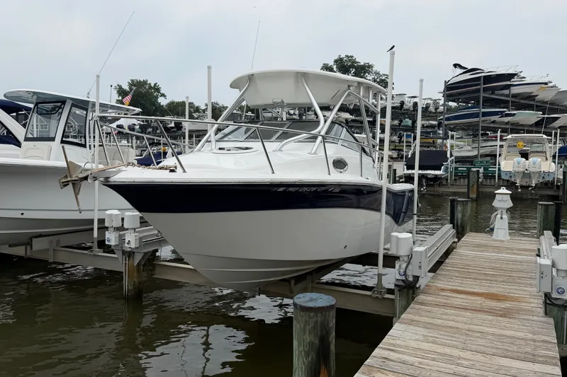 Slide: The Image of 2013 Sea Fox 256 Voyager boat docked at marina, surrounded by other vessels. - 6