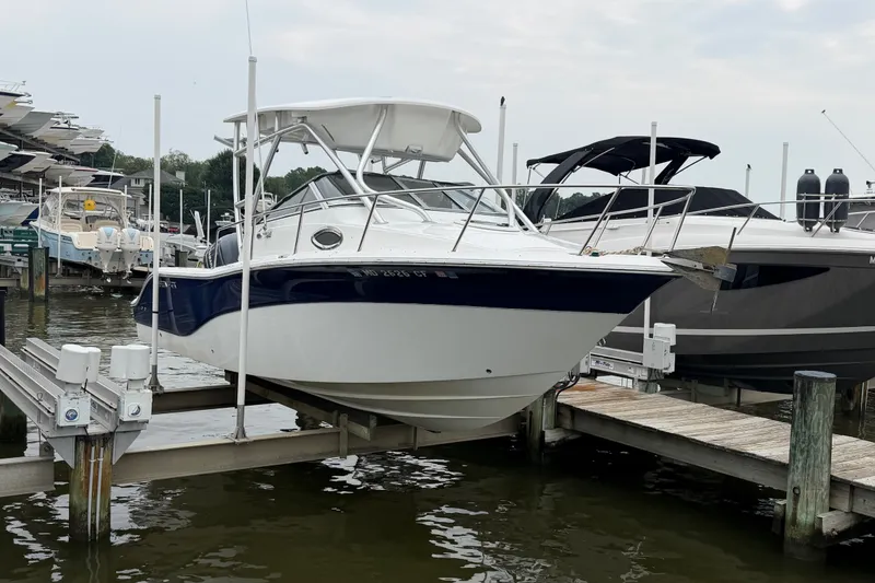 The Image of 2013 Sea Fox 256 Voyager boat docked at marina, featuring sleek design and white hull. - 0