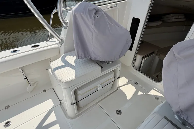 Slide: The Image of 2013 Sea Fox 256 Voyager boat interior with covered seats and cabin entrance. - 16