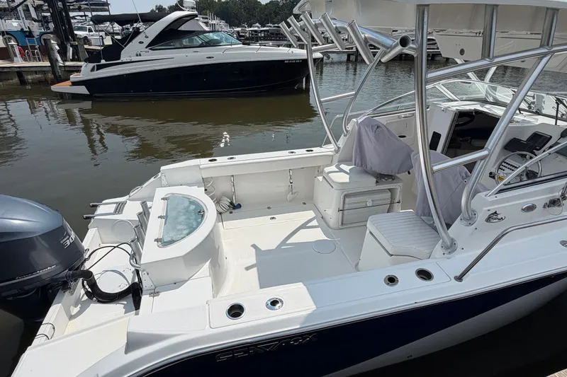 Slide: The Image of 2013 Sea Fox 256 Voyager boat docked, featuring spacious deck and modern amenities. - 12