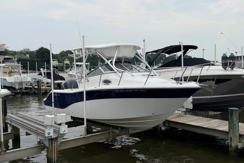 Slide: The Image of 2013 Sea Fox 256 Voyager boat docked at a marina, featuring sleek design and white hull. - 4