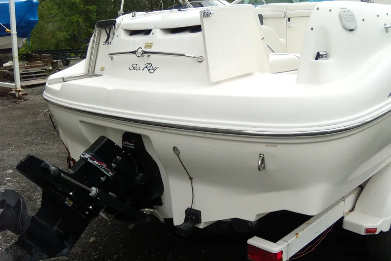Slide: The Image of 1998 Sea Ray 210 Sundeck boat rear view, featuring outboard motor and sleek white design. - 1