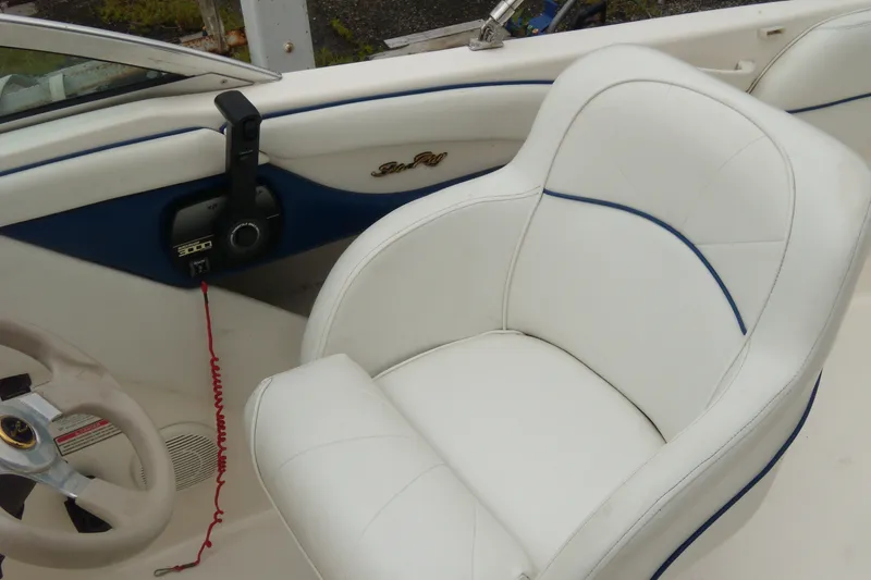 Slide: The Image of Interior of a 1998 Sea Ray 210 Sundeck boat with white seating and steering wheel. - 4