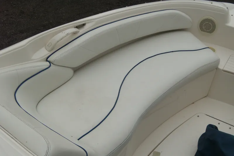 Slide: The Image of 1998 Sea Ray 210 Sundeck boat interior with white cushioned seating. - 8