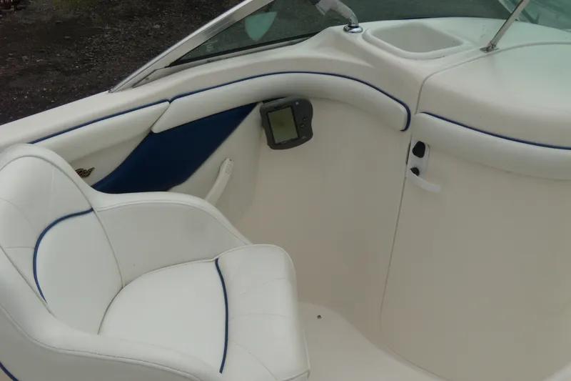 Slide: The Image of Interior of a 1998 Sea Ray 210 Sundeck boat with white seating and blue accents. - 7