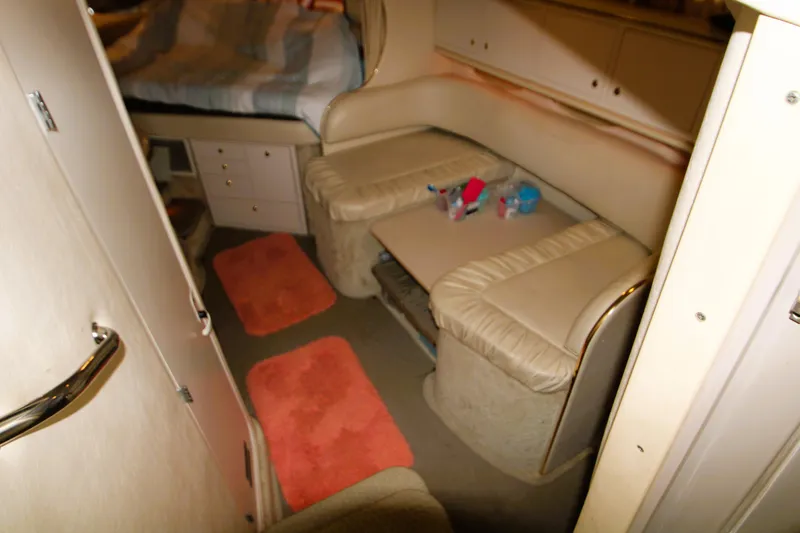 Slide: The Image of Interior of 2000 Sea Ray 310 Sundancer with beige seating and orange rugs. - 19