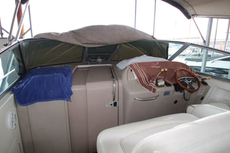 Slide: The Image of Interior of 2000 Sea Ray 310 Sundancer boat with covered dashboard and steering wheel. - 10