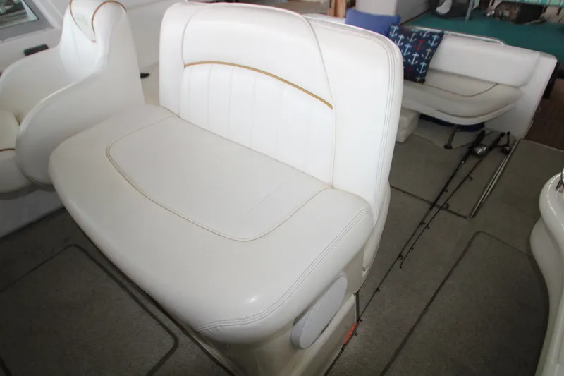 Slide: The Image of Interior seating of 2000 Sea Ray 310 Sundancer boat, featuring white cushioned seats. - 11