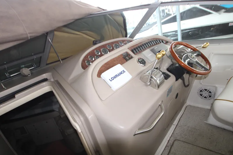 Slide: The Image of Sea Ray 310 Sundancer 2000 boat cockpit with steering wheel and control panel. - 14