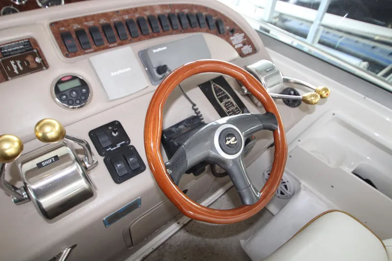 Slide: The Image of Dashboard of a 2000 Sea Ray 310 Sundancer boat with wooden steering wheel. - 18