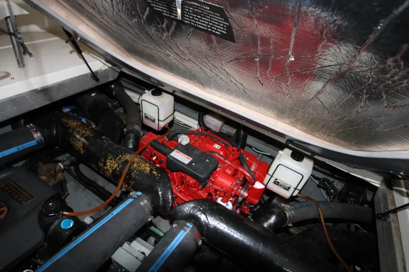 Slide: The Image of Engine compartment of 2000 Sea Ray 310 Sundancer boat, featuring red engine components. - 31