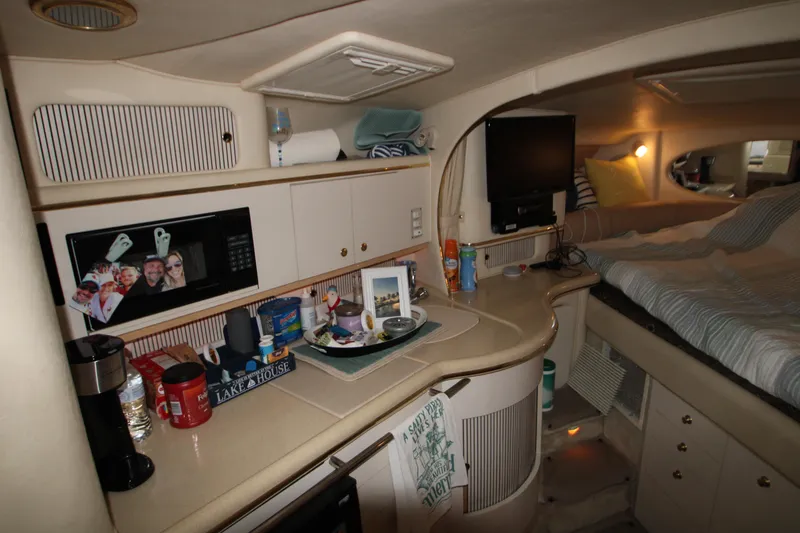 Slide: The Image of Interior of 2000 Sea Ray 310 Sundancer yacht with cozy cabin and kitchenette. - 23