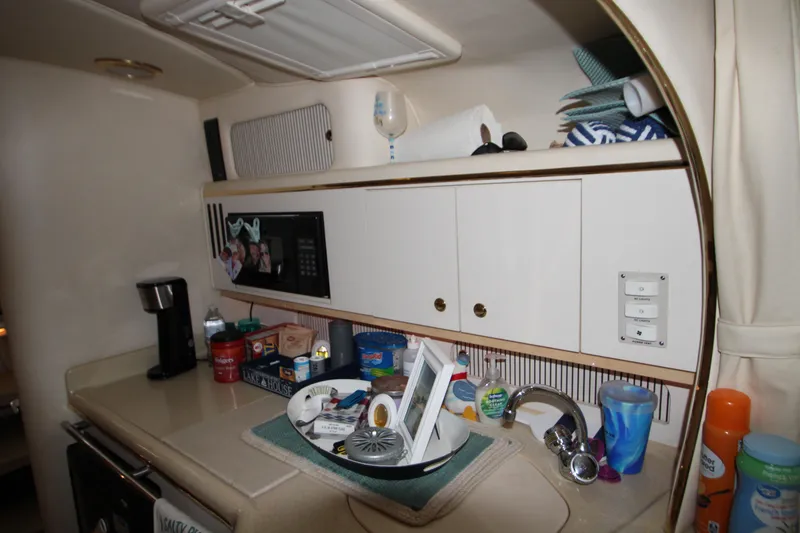 Slide: The Image of Interior of 2000 Sea Ray 310 Sundancer kitchen with cabinets and countertop items. - 25