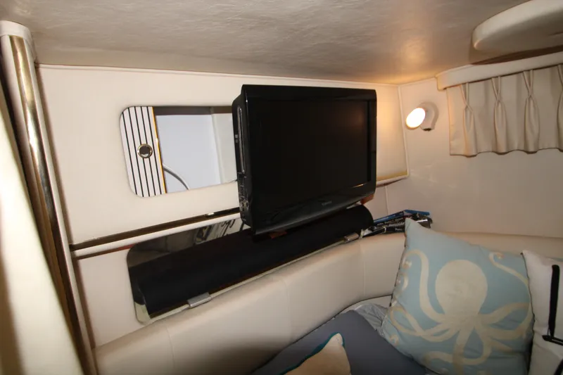 Slide: The Image of Interior of 2000 Sea Ray 310 Sundancer with TV and nautical-themed decor. - 21