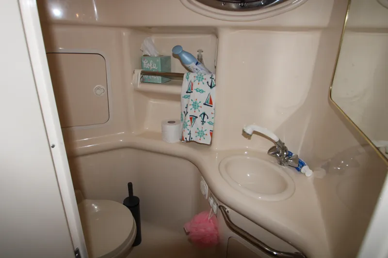 Slide: The Image of 2000 Sea Ray 310 Sundancer bathroom with sink, toilet, and storage shelves. - 28