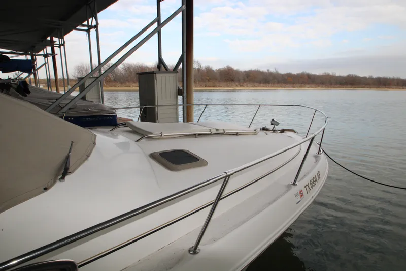 Slide: The Image of 2000 Sea Ray 310 Sundancer docked by a calm lake under a cloudy sky. - 7