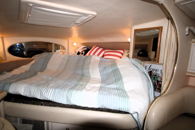 Slide: The Image of Cozy cabin interior of 2000 Sea Ray 310 Sundancer with striped bedding. - 24