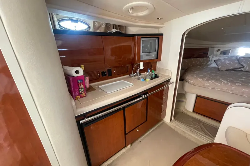 Slide: The Image of 2003 Sea Ray 360 Sundancer interior with kitchenette and cozy sleeping area. - 19