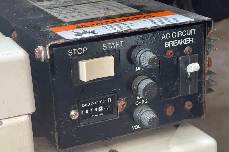 Slide: The Image of Control panel with stop/start buttons and AC circuit breaker on a 2003 Sea Ray 360 Sundancer. - 40