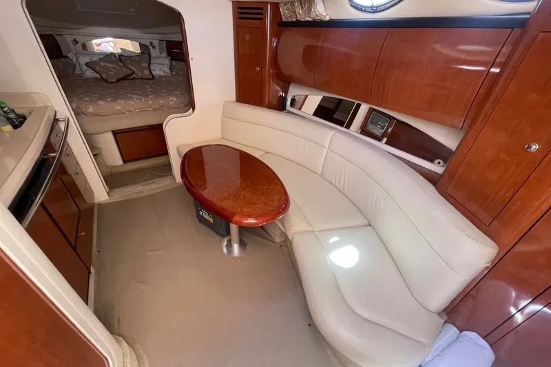 Slide: The Image of Interior of 2003 Sea Ray 360 Sundancer with curved seating and wooden table. - 17