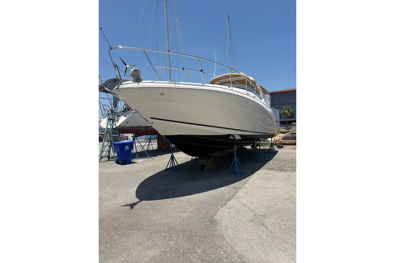 Slide: The Image of 2003 Sea Ray 360 Sundancer yacht on stands in a boatyard under clear blue sky. - 4