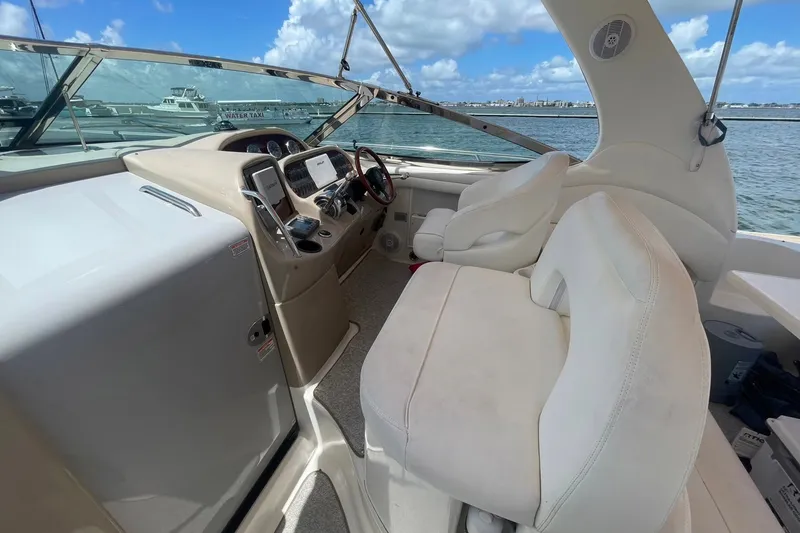 Slide: The Image of Interior view of 2003 Sea Ray 360 Sundancer yacht cockpit with white seating and control panel. - 13