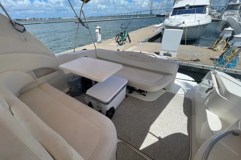 Slide: The Image of 2003 Sea Ray 360 Sundancer yacht interior with seating and table at marina dock. - 11