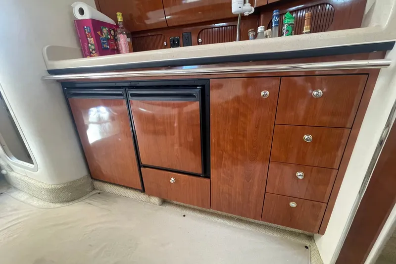 Slide: The Image of 2003 Sea Ray 360 Sundancer interior kitchen with wooden cabinets and countertop. - 29