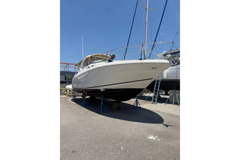 Slide: The Image of 2003 Sea Ray 360 Sundancer yacht on stands, ready for maintenance under clear blue sky. - 2