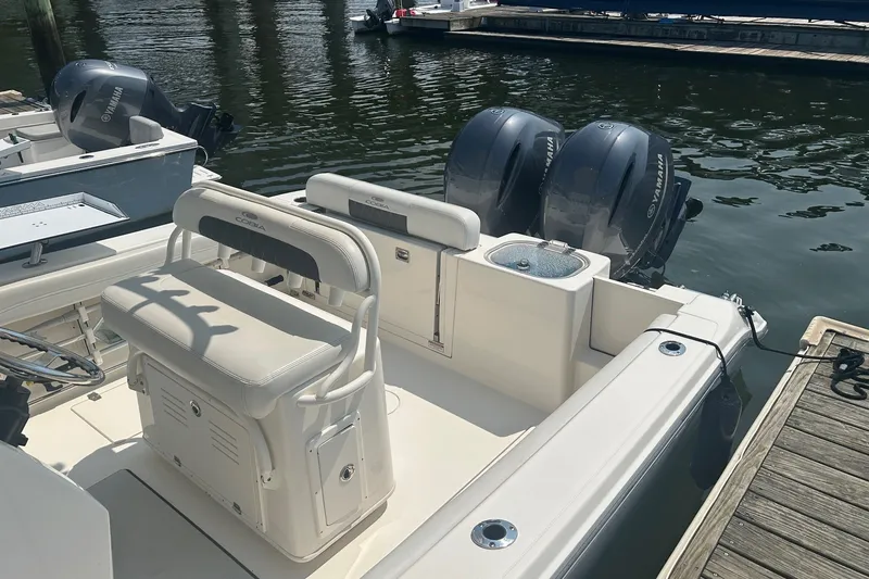 Slide: The Image of 2024 Cobia 240 Center Console boat with dual Yamaha engines docked at marina. - 10