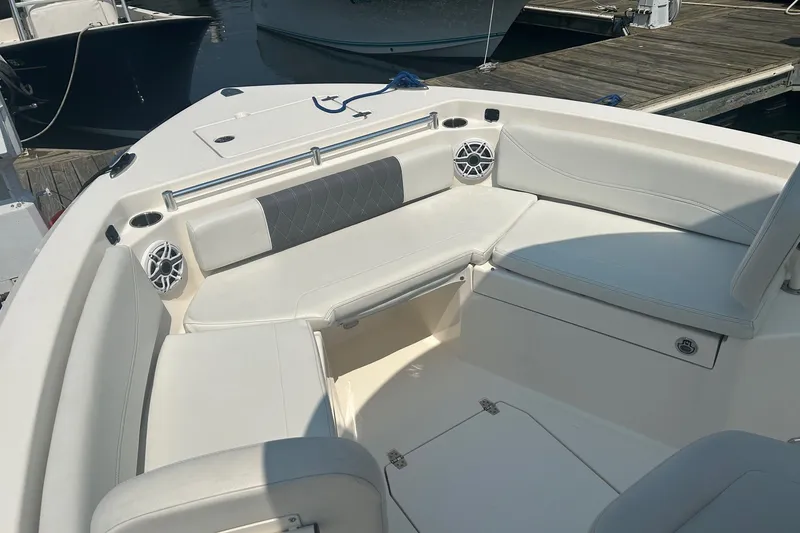 Slide: The Image of 2024 Cobia 240 Center Console boat interior with white seating and speakers. - 6