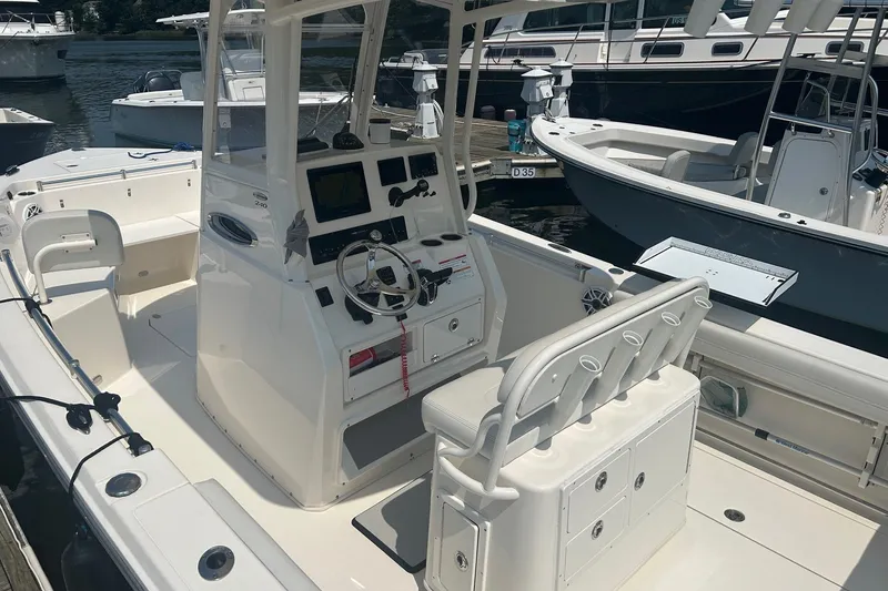 Slide: The Image of 2024 Cobia 240 Center Console boat with modern helm and seating at marina. - 8
