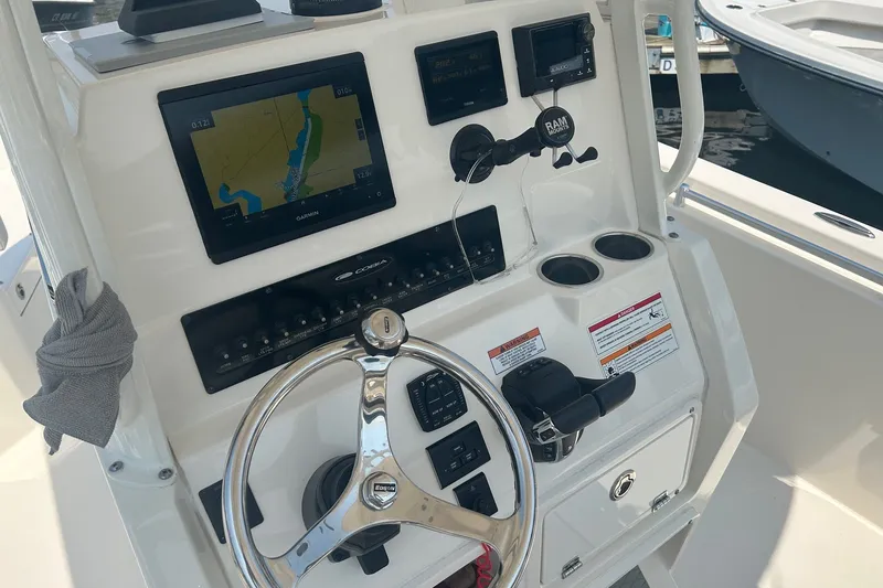 Slide: The Image of 2024 Cobia 240 Center Console dashboard with navigation system and steering wheel. - 9