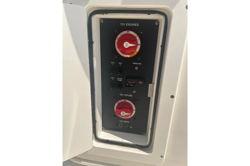 Slide: The Image of 2024 Cobia 240 Center Console electrical panel with 12V engine controls and switches. - 14