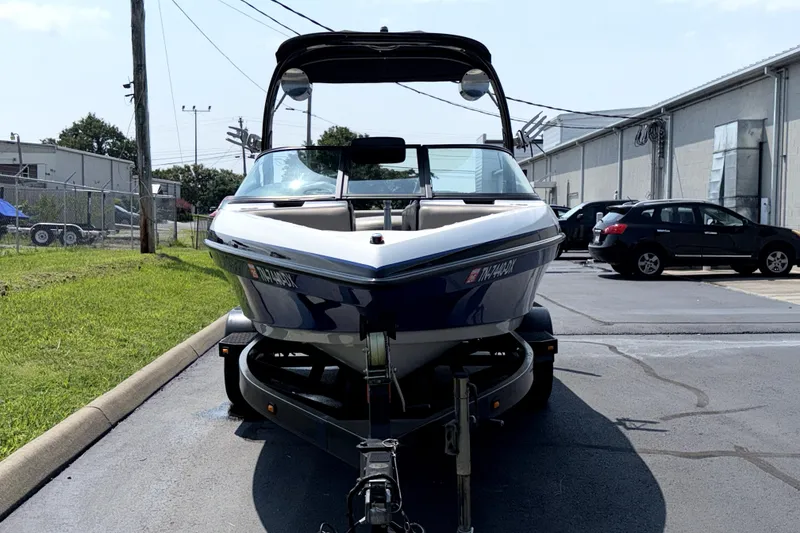 Slide: The Image of 2008 Malibu iRide boat on trailer in industrial parking lot. - 3